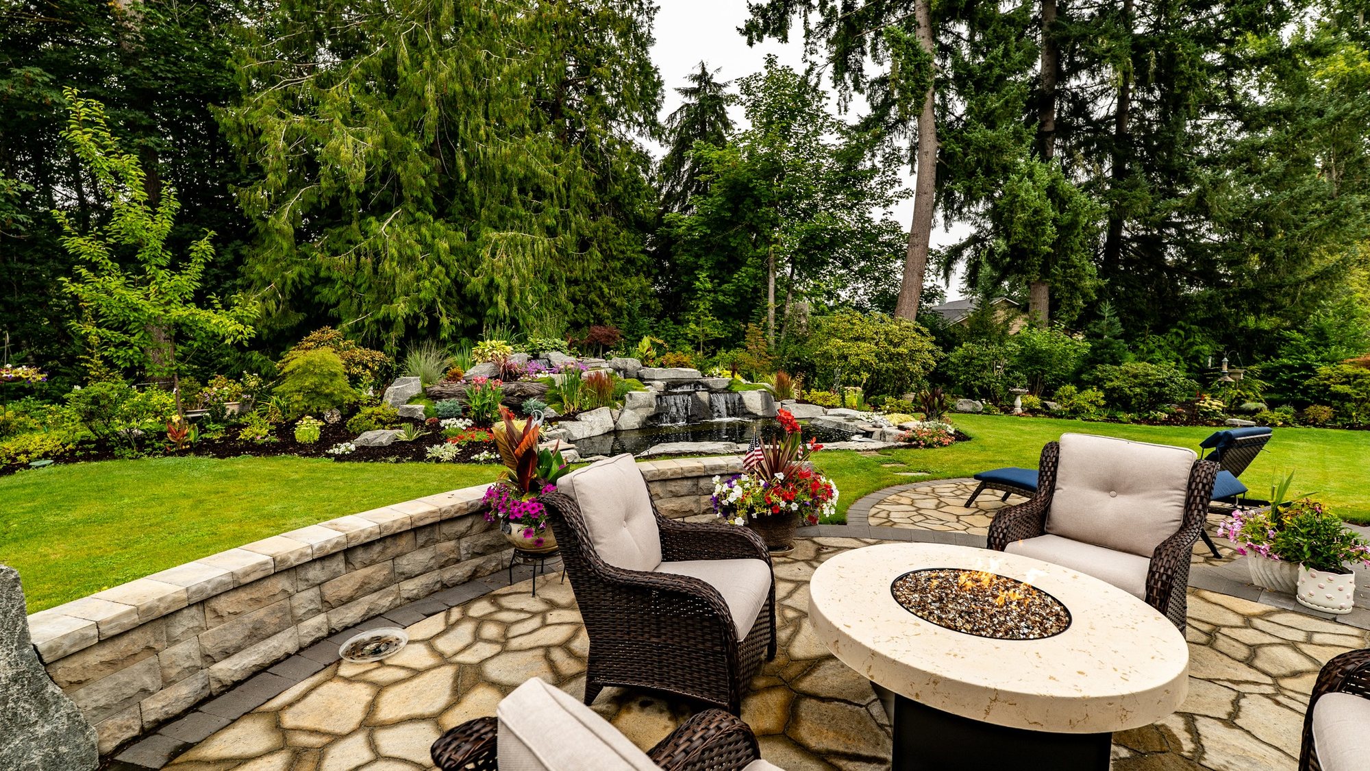 Outdoor living patio with fire pit seating and layered planting